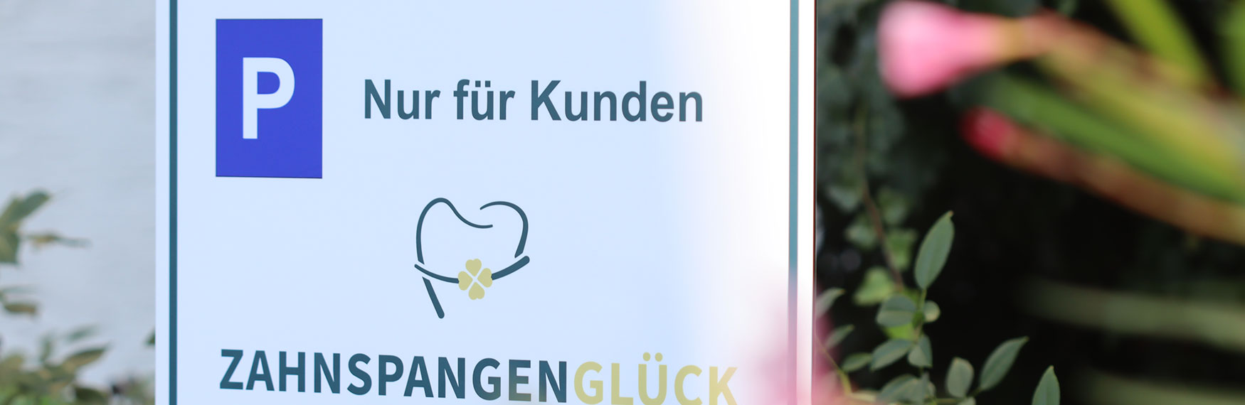 Parkpatzschild der kieferorthopaedischen Praxis Zahnspangenglueck